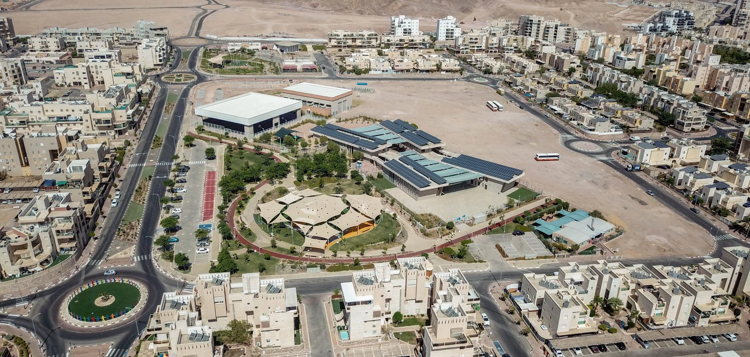 בית הספר ים סוף באילת עם פאנלים סולאריים על הגגות וכיכר מעגלית מעוצבת, מבנה חינוך של סמי נופי ובניו