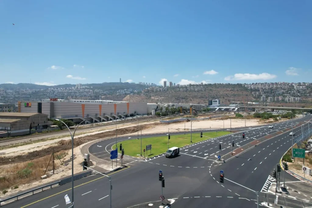 כביש מבוא דרך הכרמל בחיפה על רקע מרכז מסחרי ונוף הכרמל, עבודות סלילה ותשתית של סמי נופי ובניו