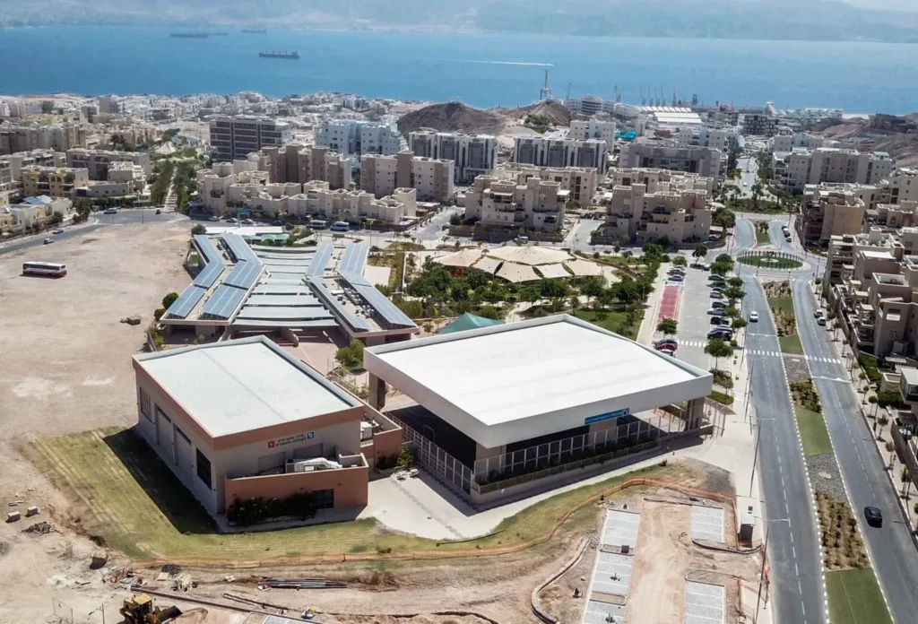 מבט אווירי על אולמות הספורט בשכונת ים סוף באילת על רקע המפרץ, מבנה ציבורי שהקימה סמי נופי ובניו